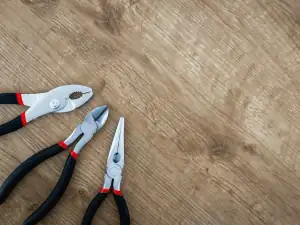 Combination and long-nose pliers on a bench