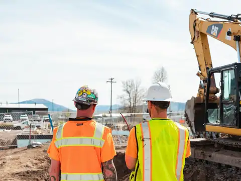 Two workers in high-visibility vests on site