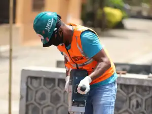 Worker breaking concrete with a demolition hammer