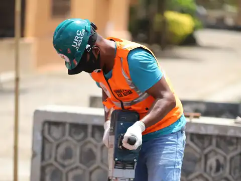 Worker breaking concrete with a demolition hammer